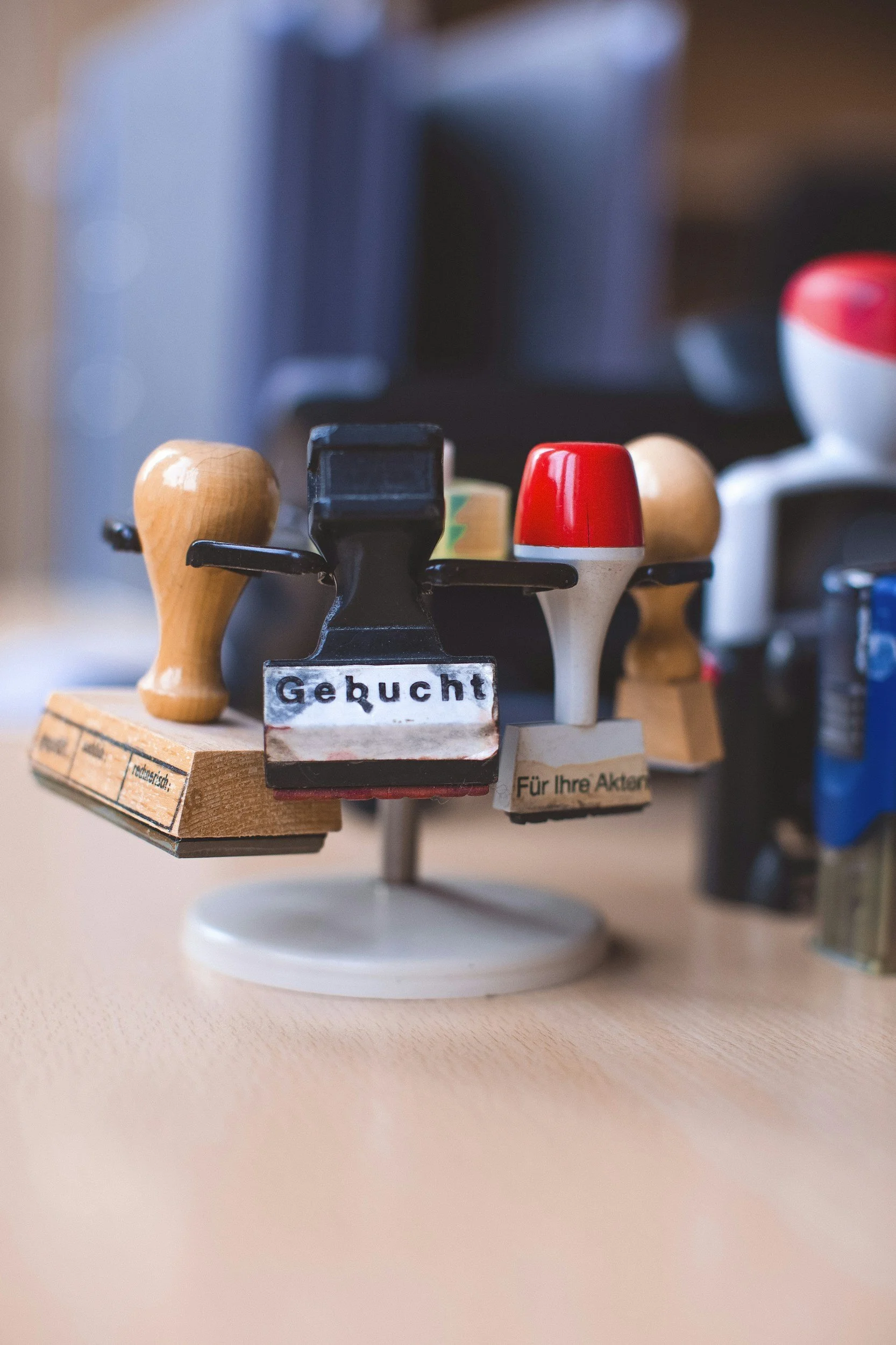 Close-up of a miniature wooden and plastic toy boat with various colored parts, with German labels, placed on a light surface.